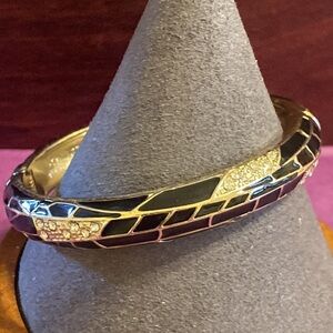 Gold tone hinged bangle with black enamel and rhinestones
